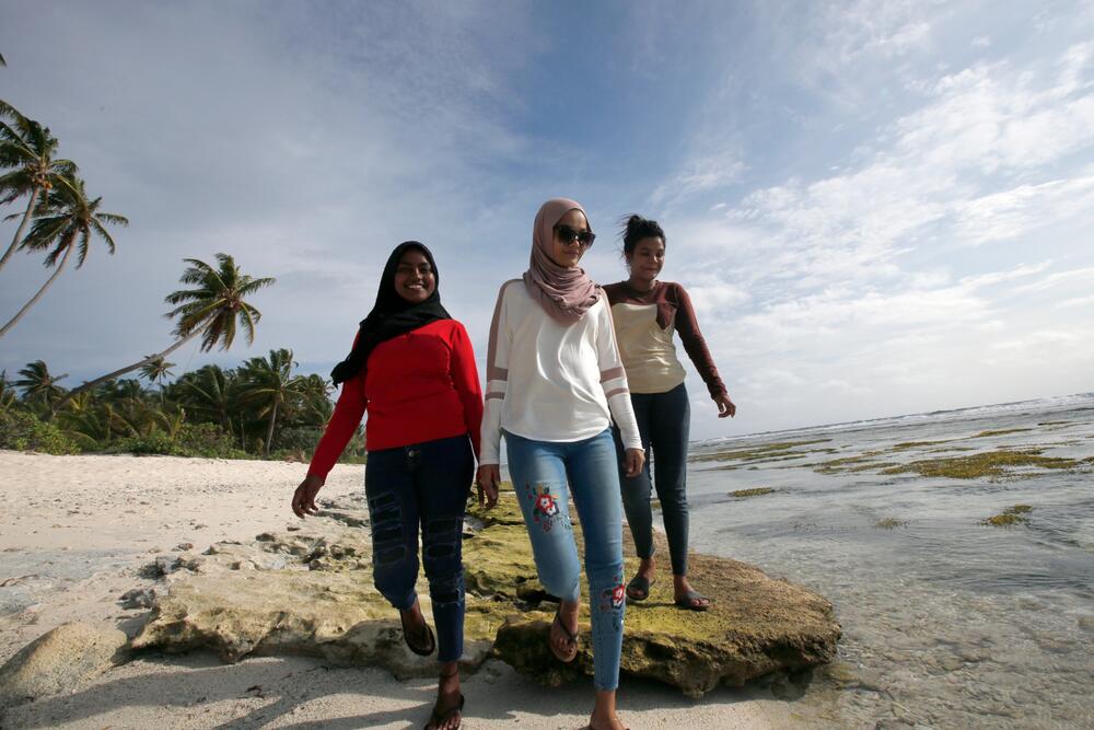 Three women walking on a beach