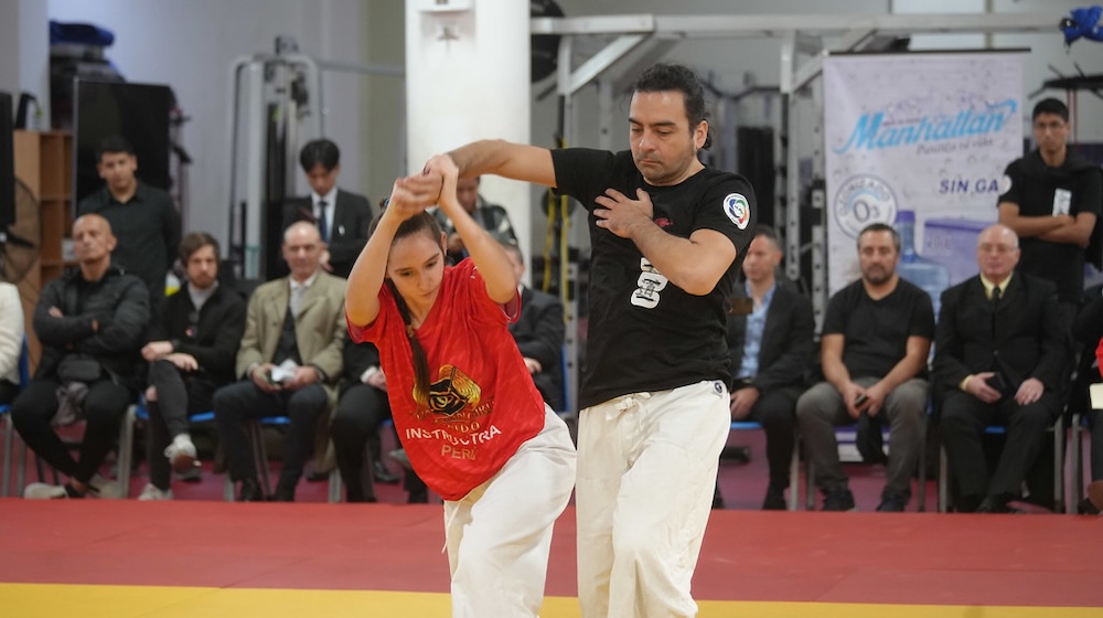 A female student practicing Aikido with a male instructor.