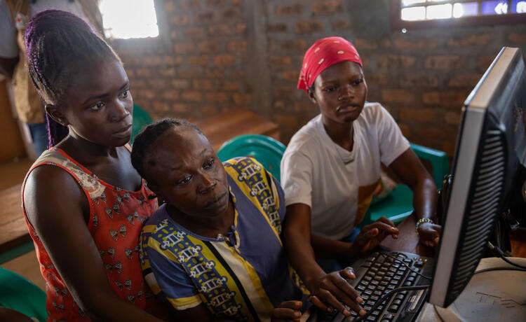 ثلاث نساء ينظرن معًا إلى شاشة كمبيوتر