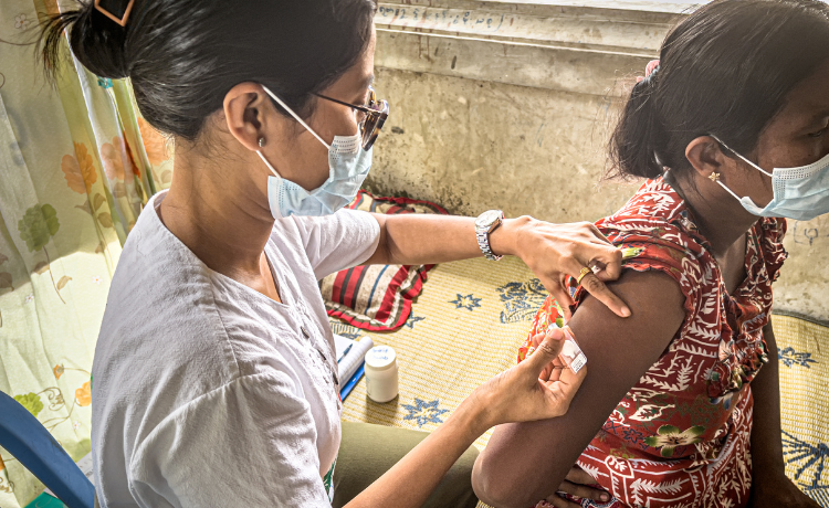  A health worker prepares to administer an injectable contraceptive in a woman’s arm