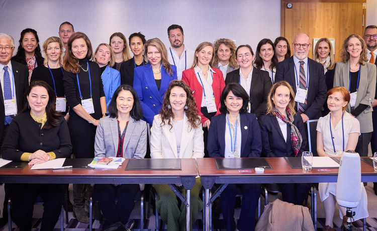 A group photo of diverse health leaders and policymakers gathered at a summit discussion table