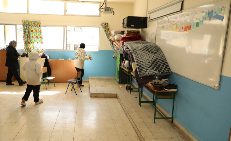 Mariam's family cleans a classroom they were assigned to shelter in, before setting up mattresses that they recently received © UNFPALebanon/Georges Roukoz