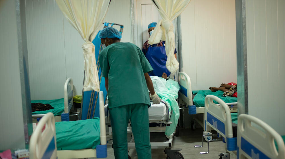 Trabajadores de la salud conducen a una paciente a una sala de maternidad.