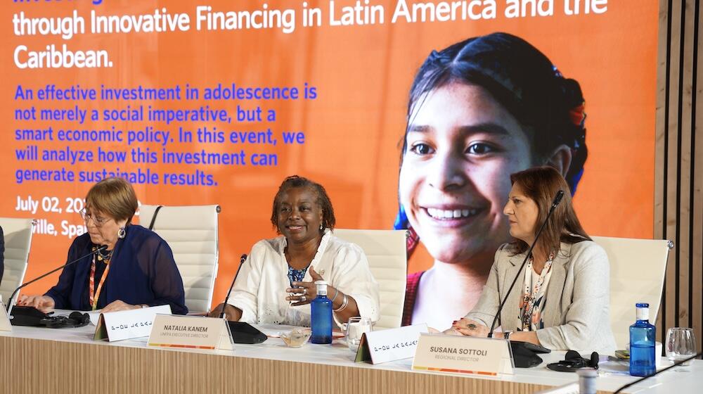 Three women including UNFPA's Executive Director are seated at a conference.