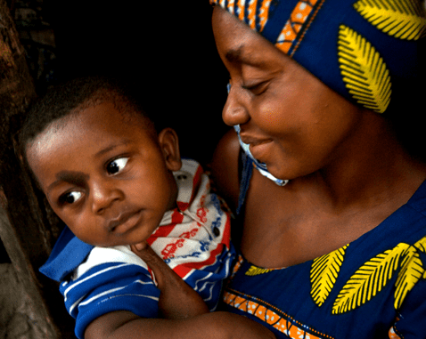 Mother and baby in the Democratic Republic of Congo A woman smiles down at her son.