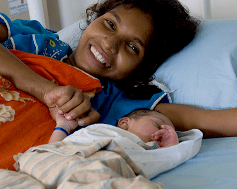 Mother and baby in Sri Lanka A mother lies next to her newborn baby.