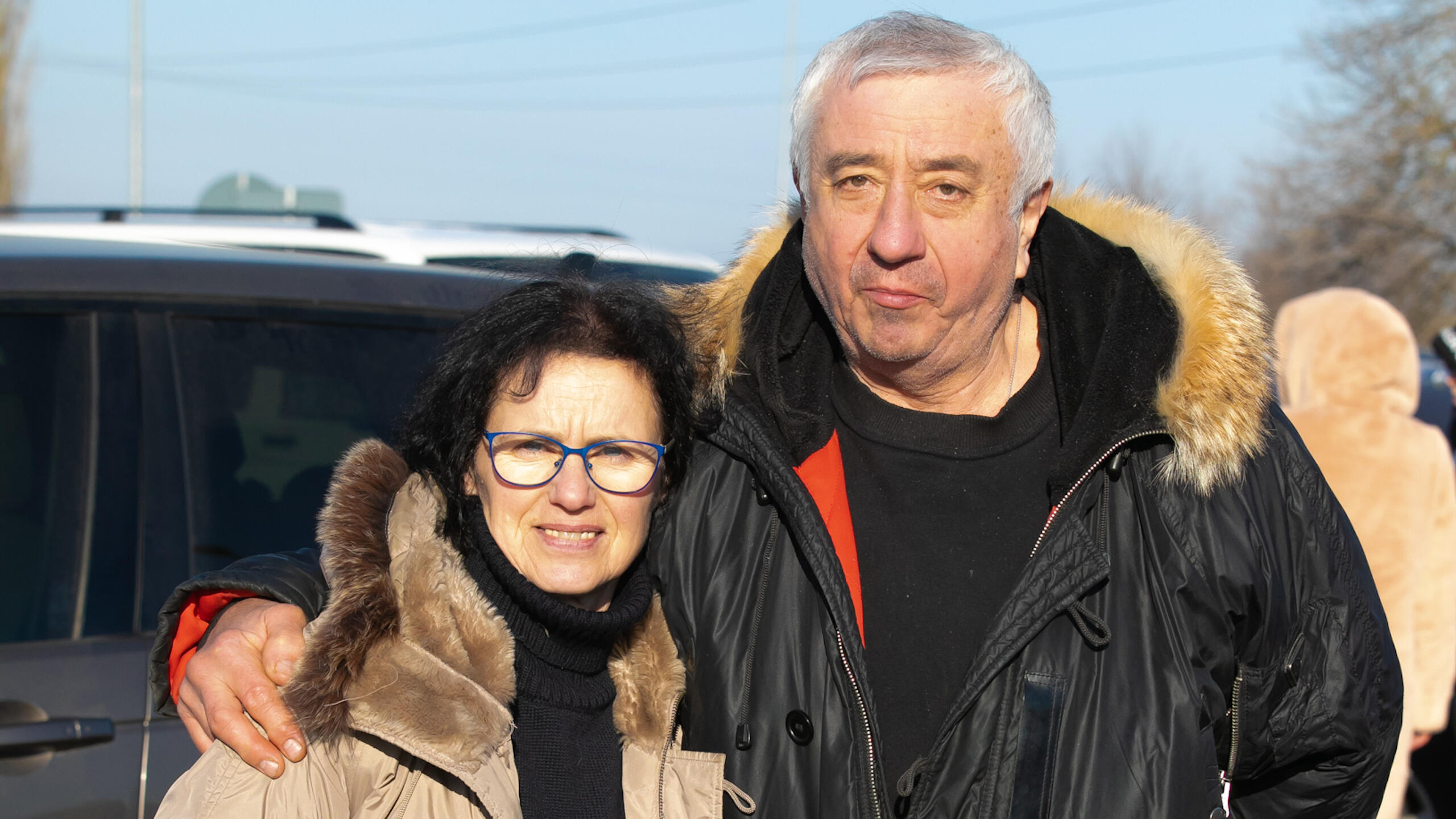 An older couple hold each other.