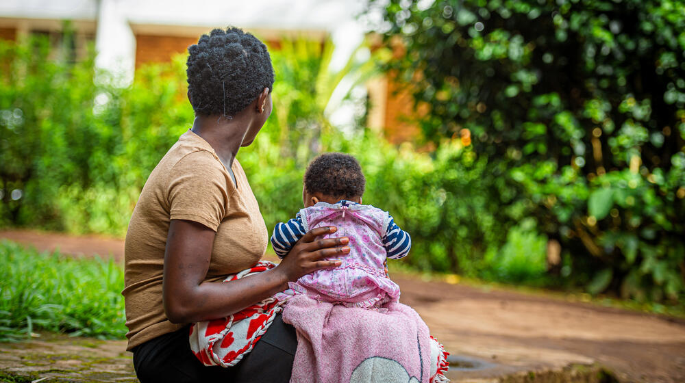 A woman and a young child are turned away from the camera. 