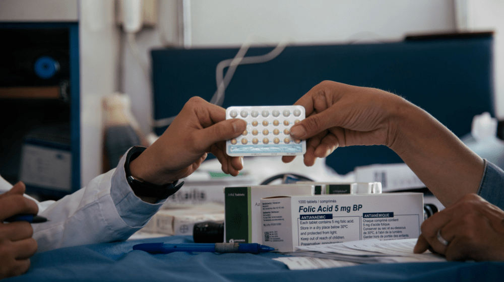 Health workers hold up a one-month pack of oral contraceptives.