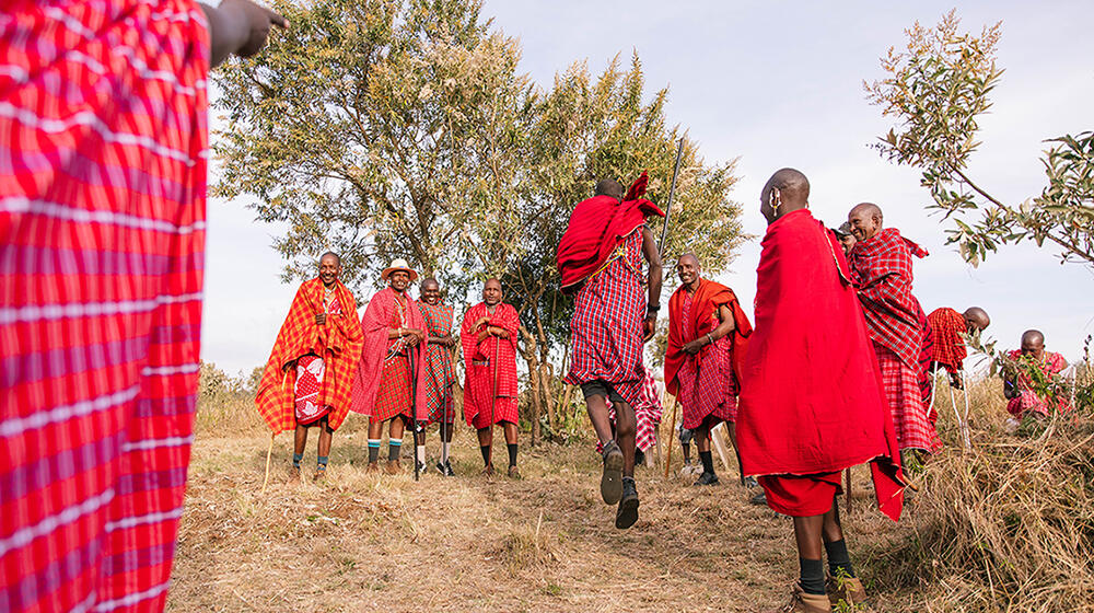 Un rassemblement d’hommes maasaï. L’un est en train d’exécuter une danse composée de sauts appelée Adumu.