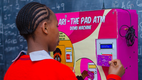  A young girl in Kenya operating a sanitary pad dispensing machine.
