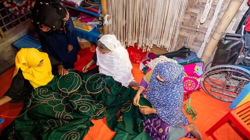 A group of women sewing fabric.