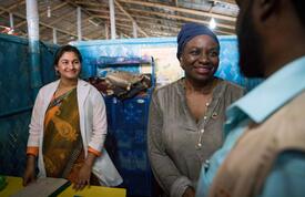 Dr. Natalia Kanem shakes the hand of a UNFPA staff member as a midwife stands to the left of her. 