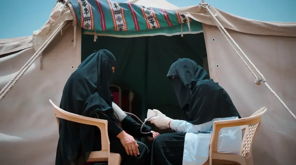 A midwife from a UNFPA mobile health clinic assesses a pregnant woman at a displacement camp in Marib, Yemen. The mobile clinic is no longer operational due to funding cuts.  ©UNFPA Yemen