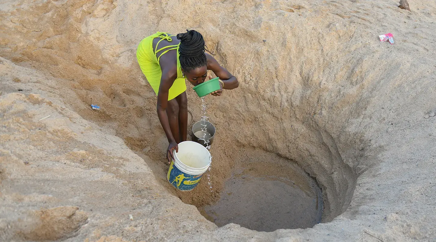 Helena recoge agua de un pozo en la aldea de Giraul, en Angola.