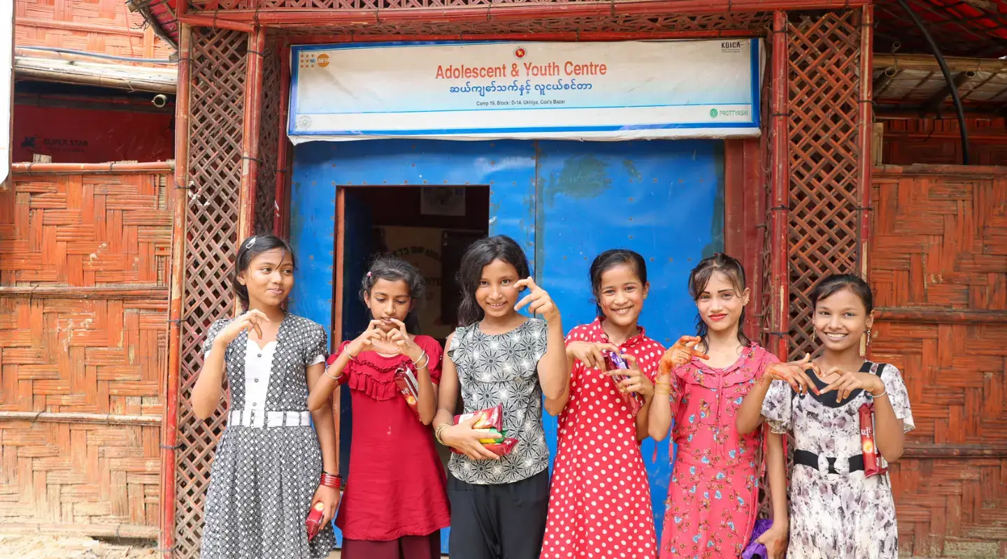 Six jeunes filles se tiennent devant un centre pour jeunes.