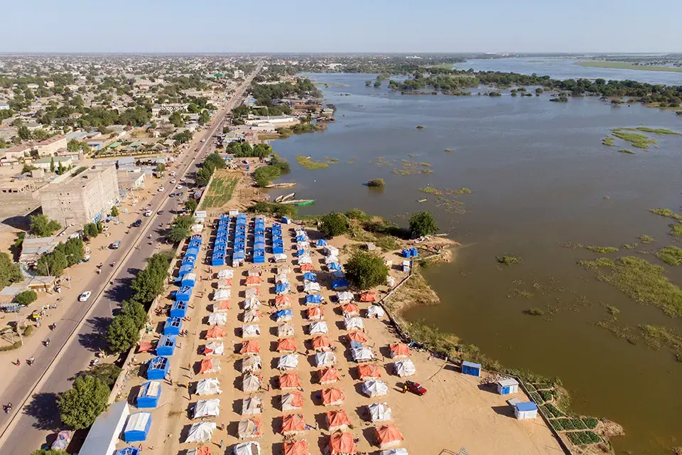 Un camp pour personnes déplacées s’étend le long du fleuve en crue.